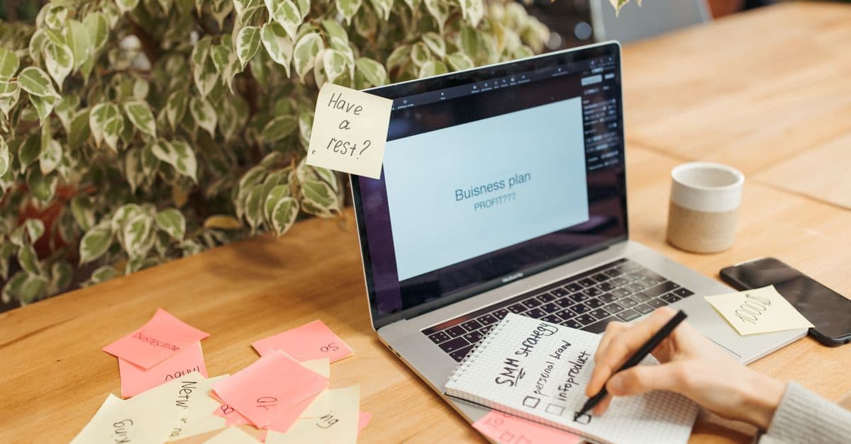 Arbeitsplatz mit Laptop, Haftnotizen und Notizblock für die Geschäftsplanung
